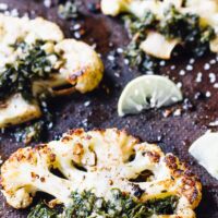 Za'atar roasted cauliflower steaks on a brown baking sheet.