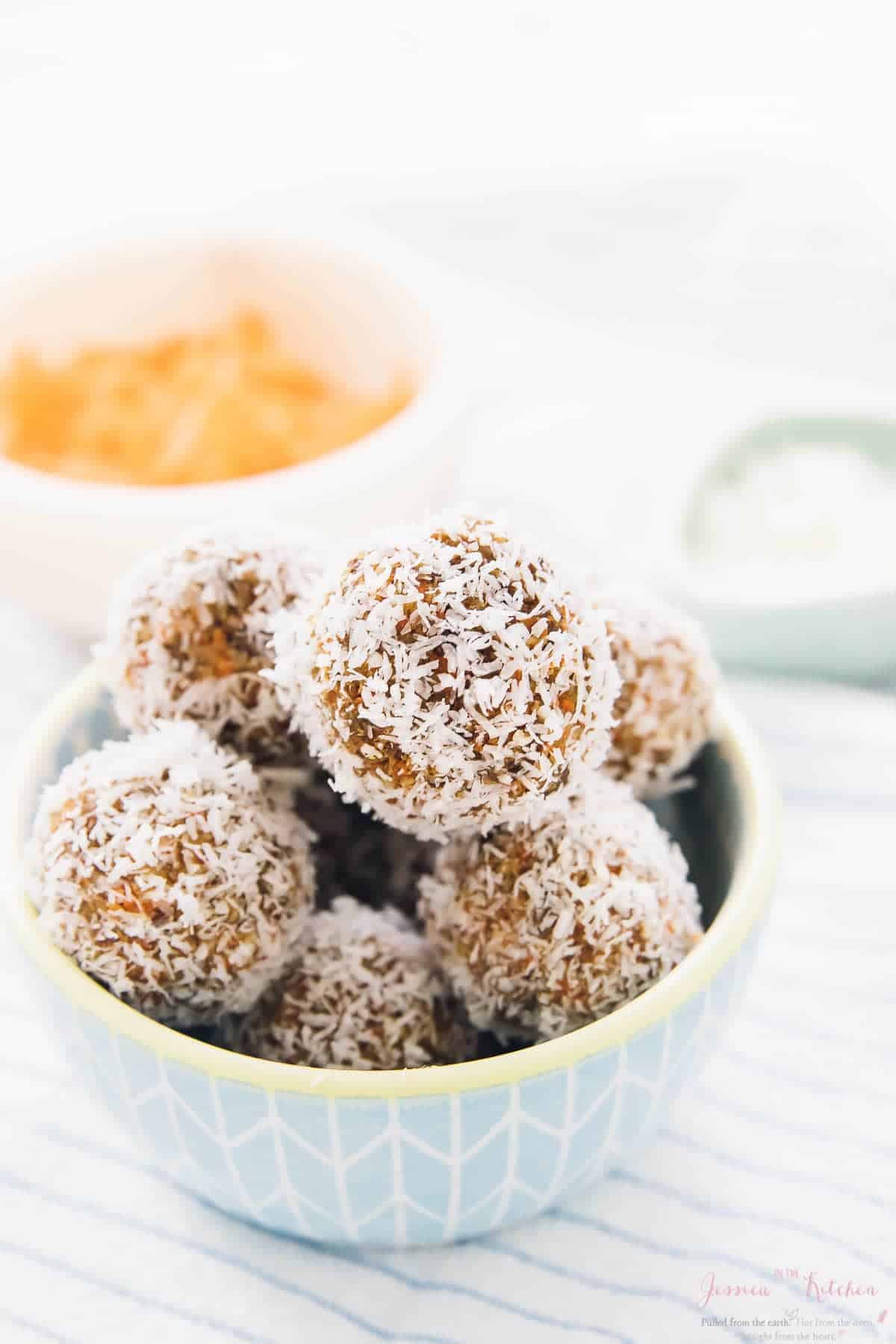 A blue bowl of no bake carrot cake energy bites.