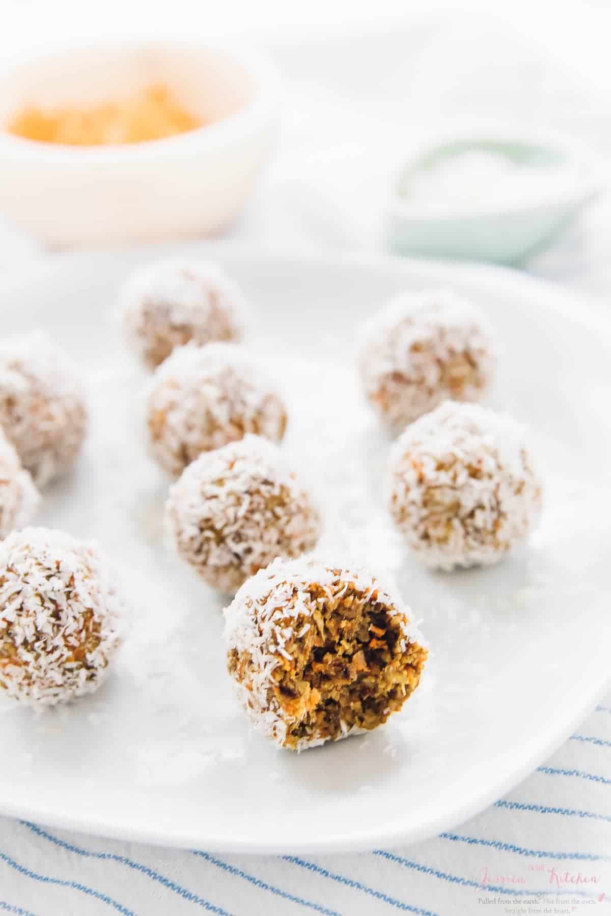 A plate of carrot cake energy bites on a striped cloth. 