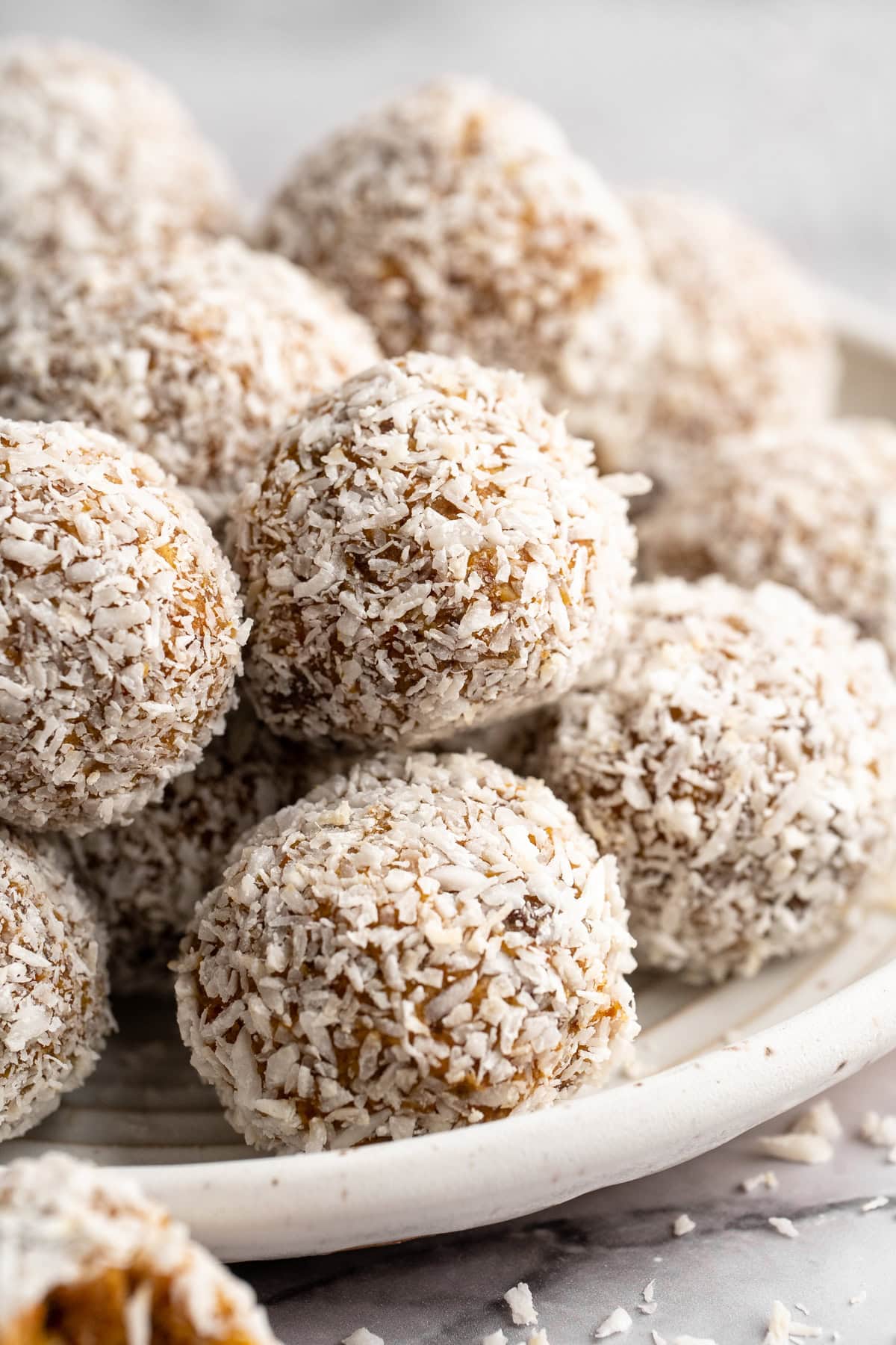 These no bake carrot cake energy bites are cozy, warmly spiced, and wholesome since they're made with nuts, carrots and dates for sweetness! Plate of no bake carrot cake energy bites.