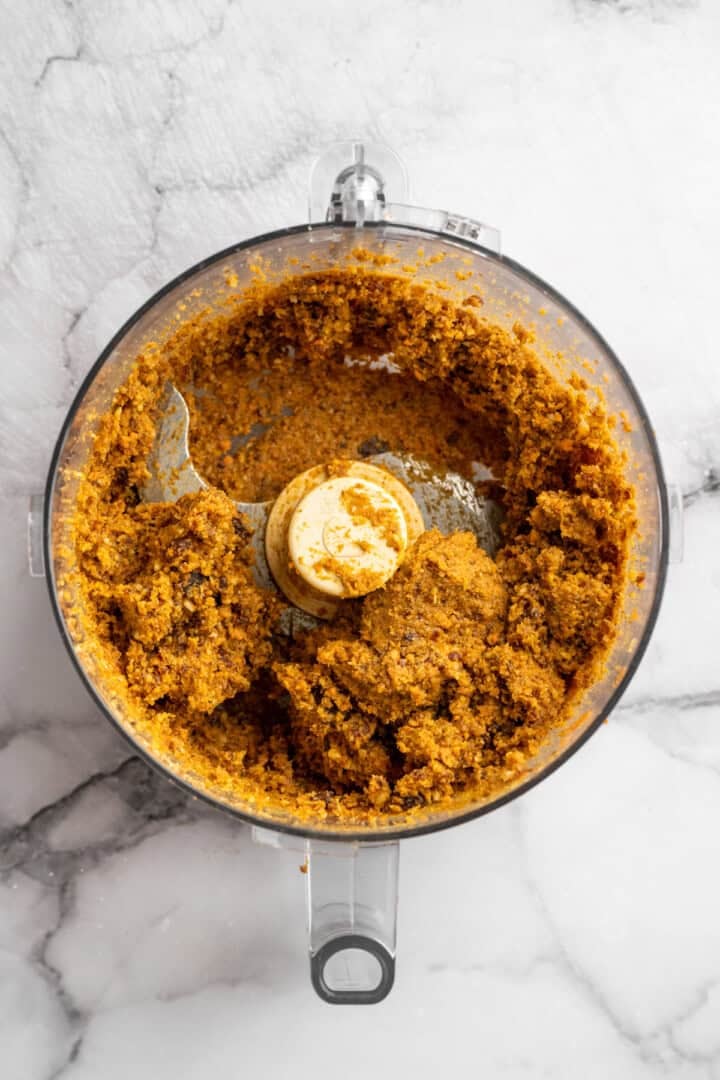These no bake carrot cake energy bites are cozy, warmly spiced, and wholesome since they're made with nuts, carrots and dates for sweetness! Mixture for carrot cake energy bites in food processor.