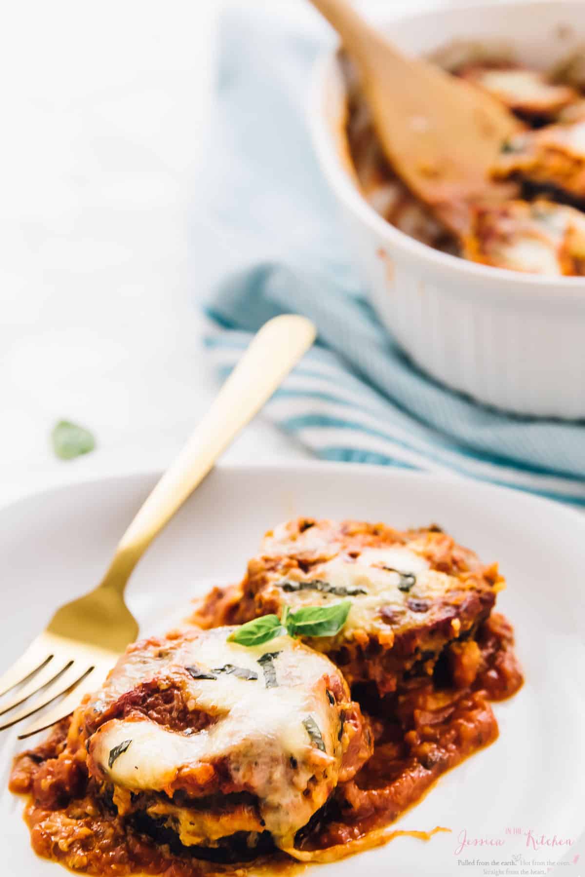 Baked eggplant parmesan on plate with gold fork