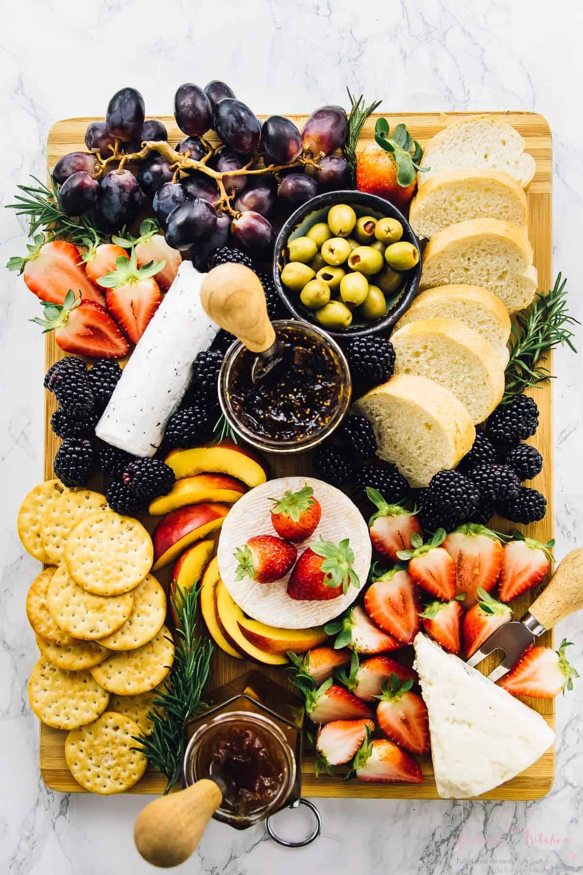 Top down shot of cheeseboard with fruit and bread.