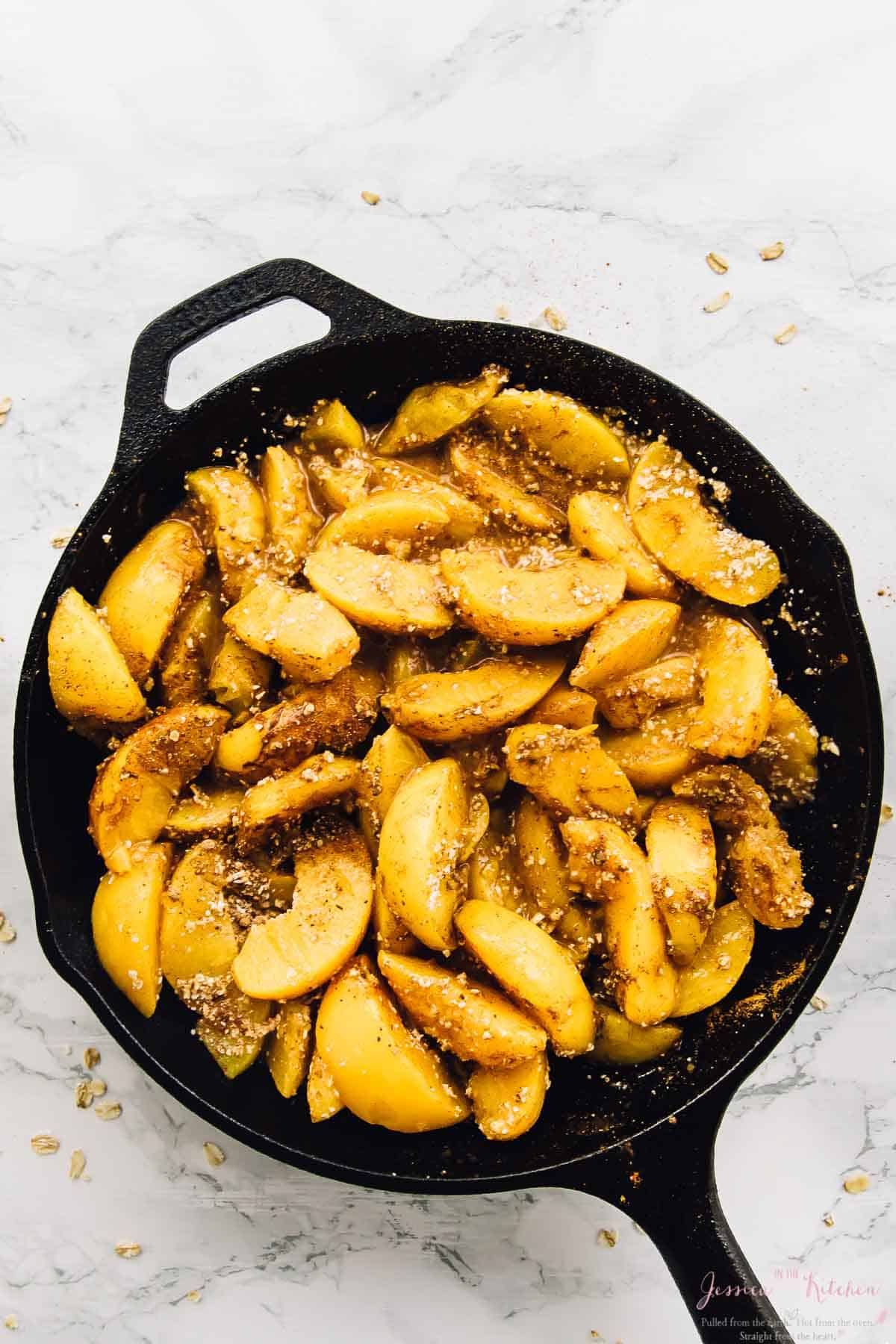 Overhead view of peach filling for cobbler in cast iron skillet