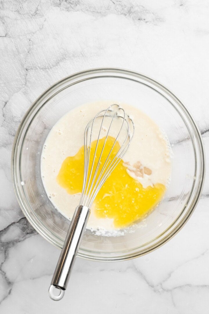 Melted vegan butter and egg replacer added to bowl of vegan buttermilk