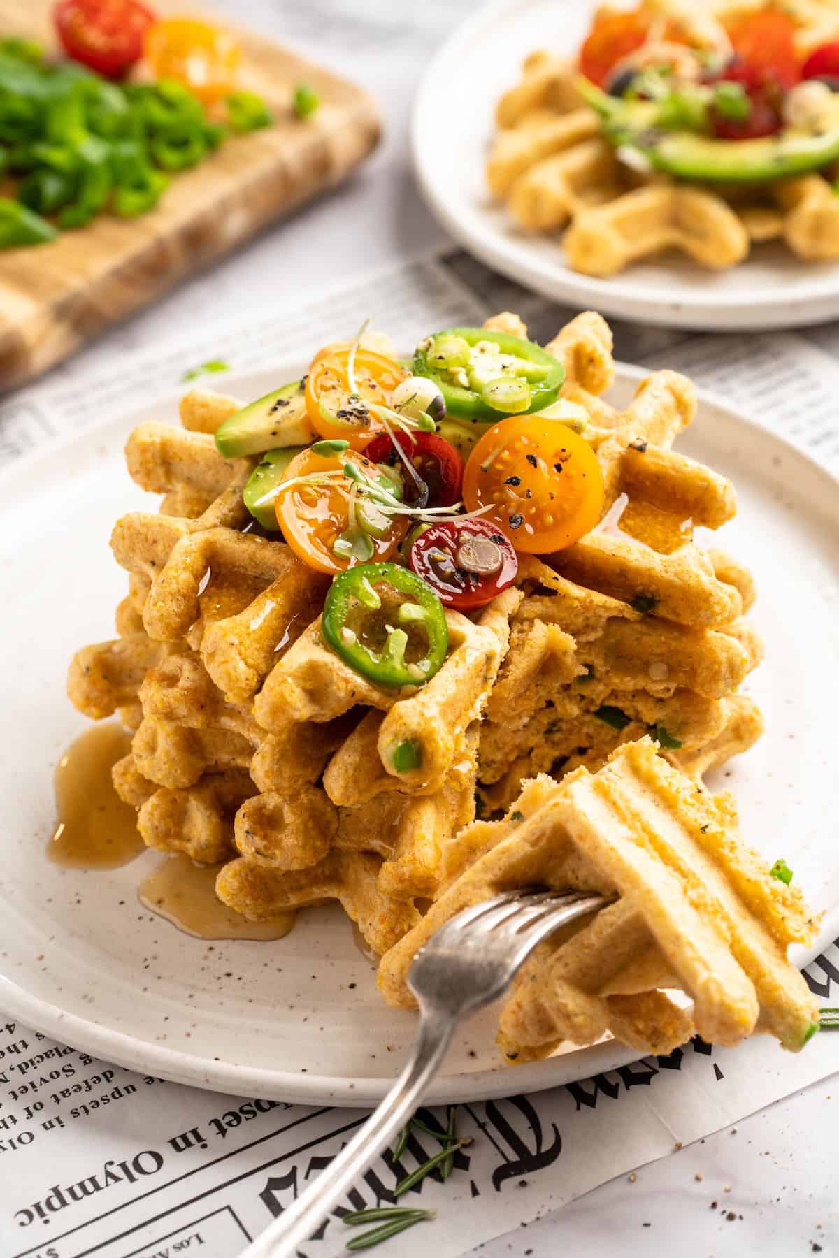 Stack of jalapeno cornbread waffles on plate with fork