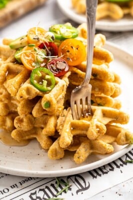 Fork sticking into pieces of cornbread waffles