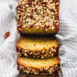 Overhead shot of vegan banana bread cut into slices on a striped cloth.