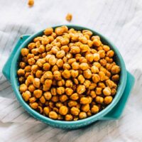 Chickpeas in a blue bowl on a striped cloth.