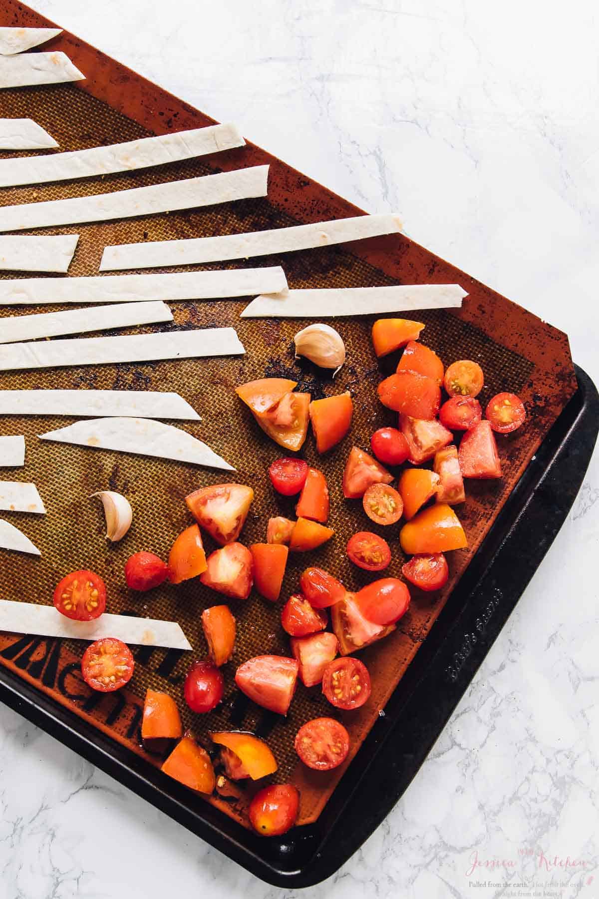 Diced tomatoes and tortilla strips on a baling sheet. 