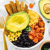 Loaded taco salad bowl with a golden fork on the side.