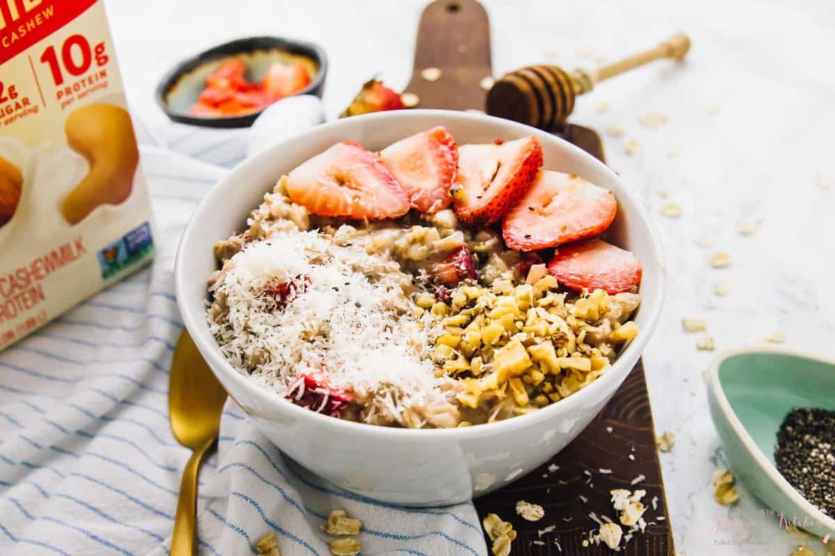 Overnight oats in a bowl, topped with coconut and strawberries. 