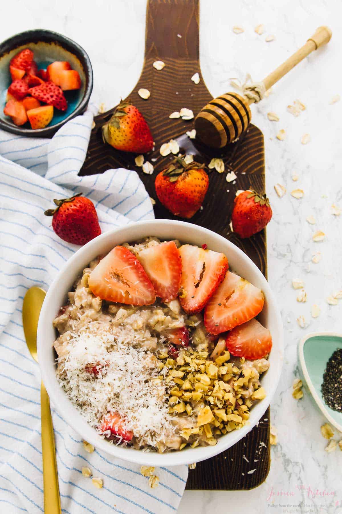 Bowl of strawberry coconut overnight oats on wood board