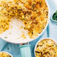 Top down view of creamy baked vegan mac & cheese in a skillet with a blue handle.