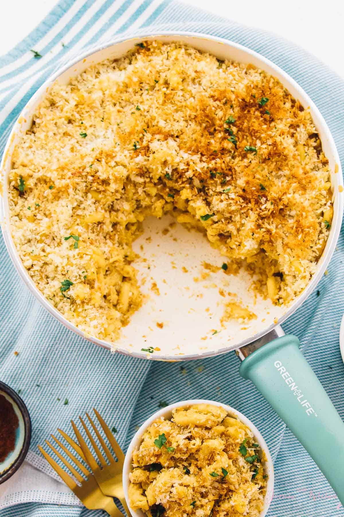 Top down view of mac and cheese in a skillet with a portion taken out. 