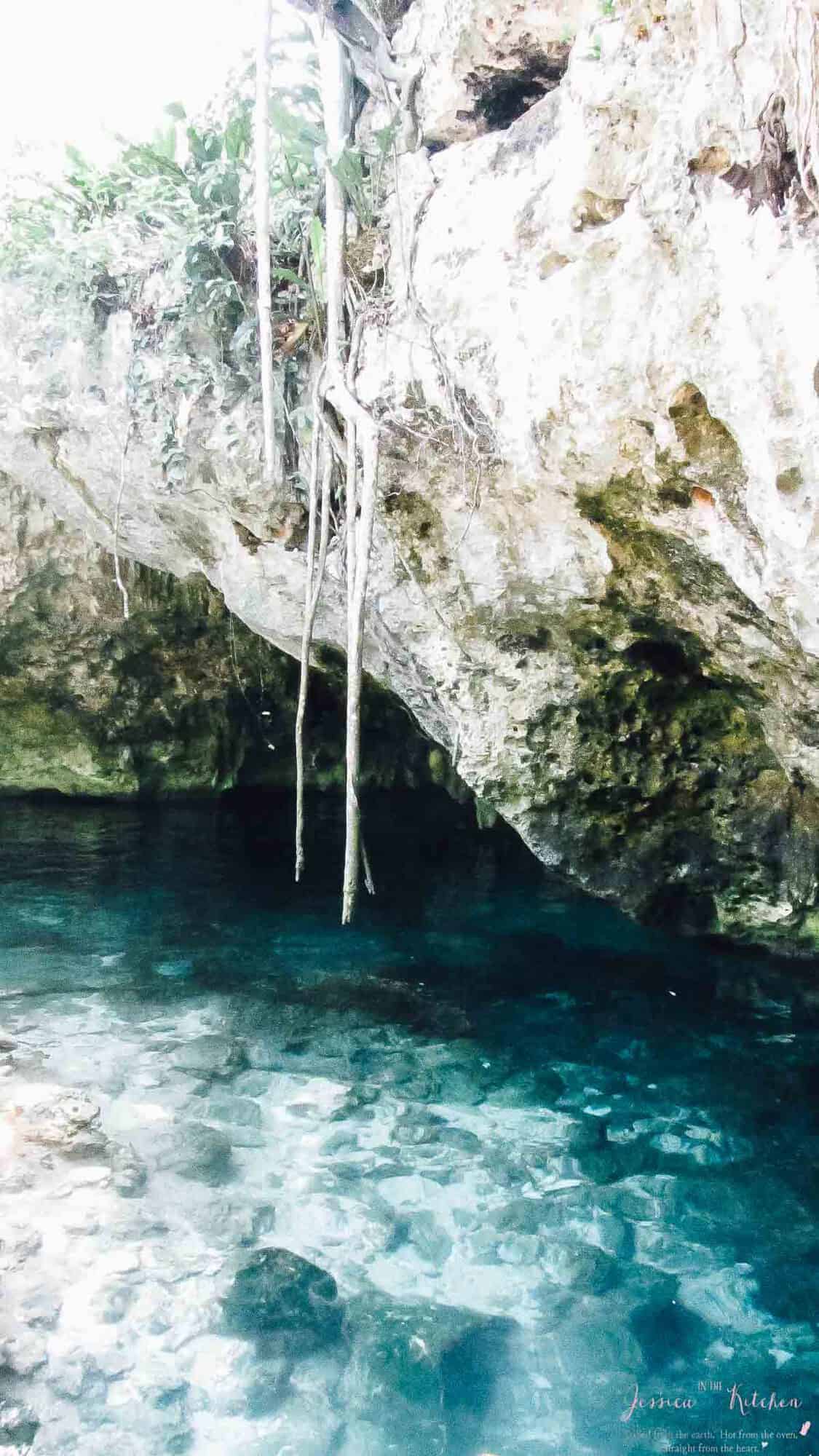 A rock cove with blue water under it. 