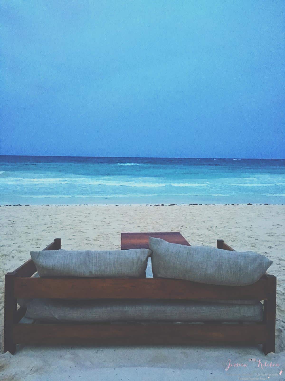 A couch on a beach. 