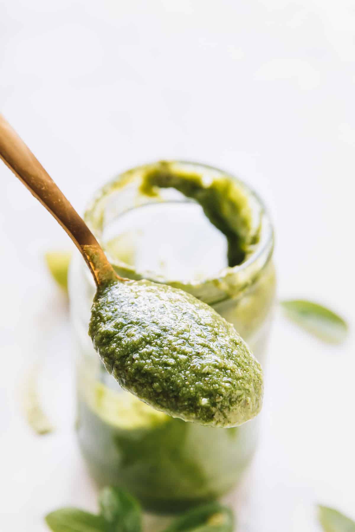 A gold spoon with basil pesto. 