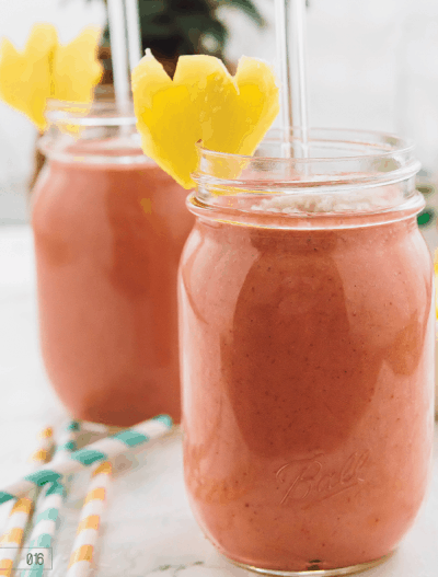 Two mason jars with pina colada smoothie. 