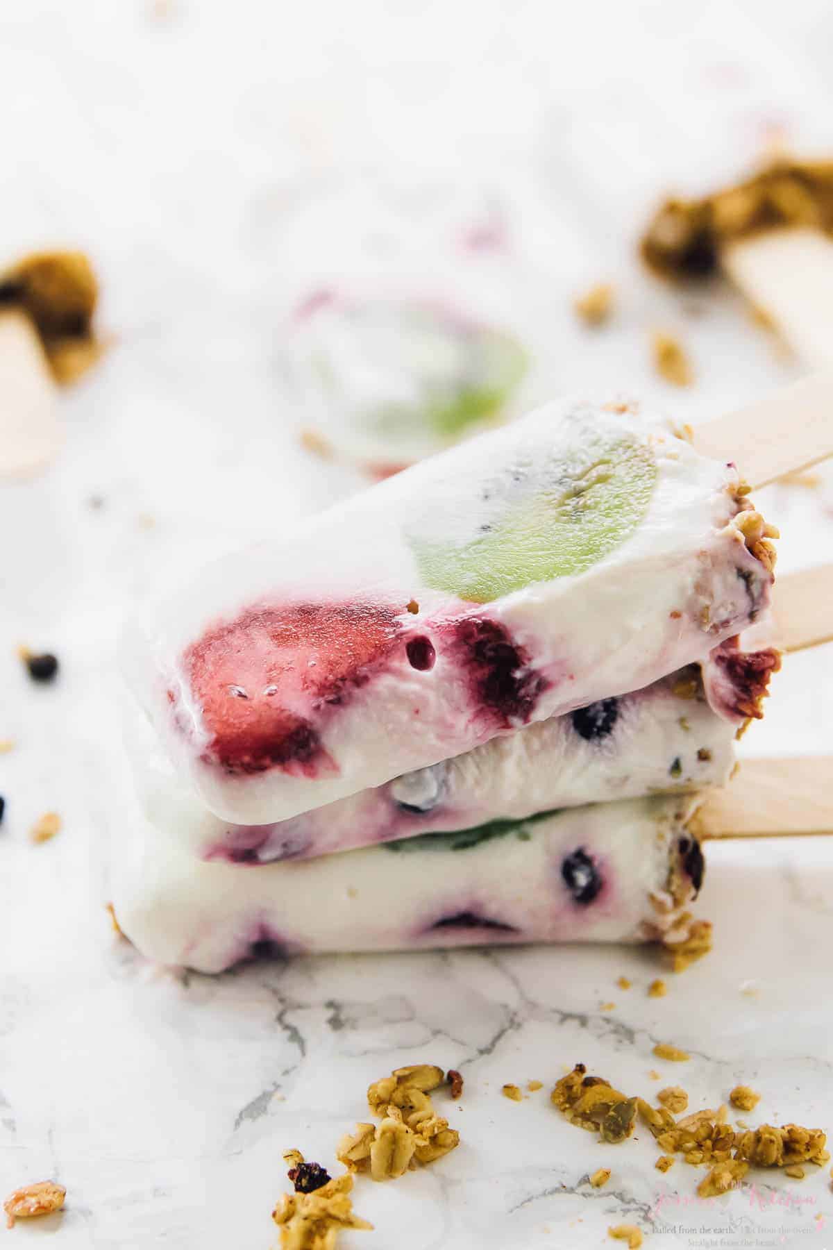 A stack of yogurt parfait popsicles on a table top. 