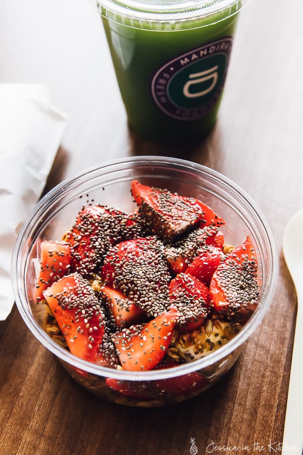 A bowl of chopped strawberries covered in poppy seeds.