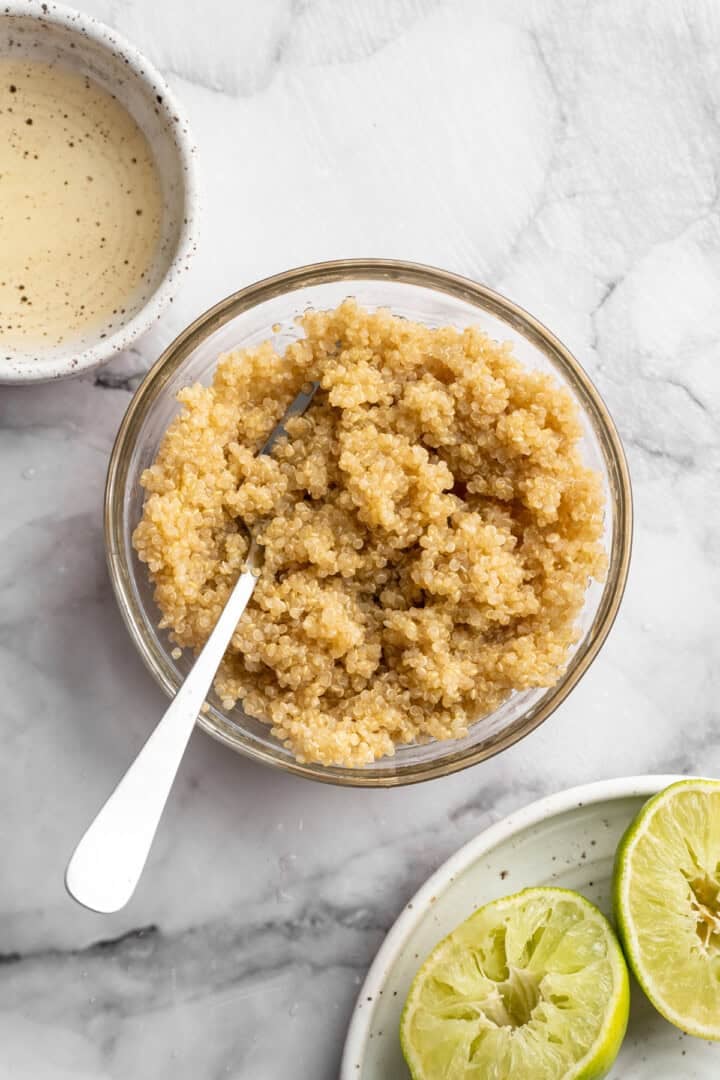 Sweet, juicy summer fruit and fluffy quinoa come together in this beautiful quinoa stone fruit salad. It’s ready in just 20 minutes! Quinoa in bowl with spoon.