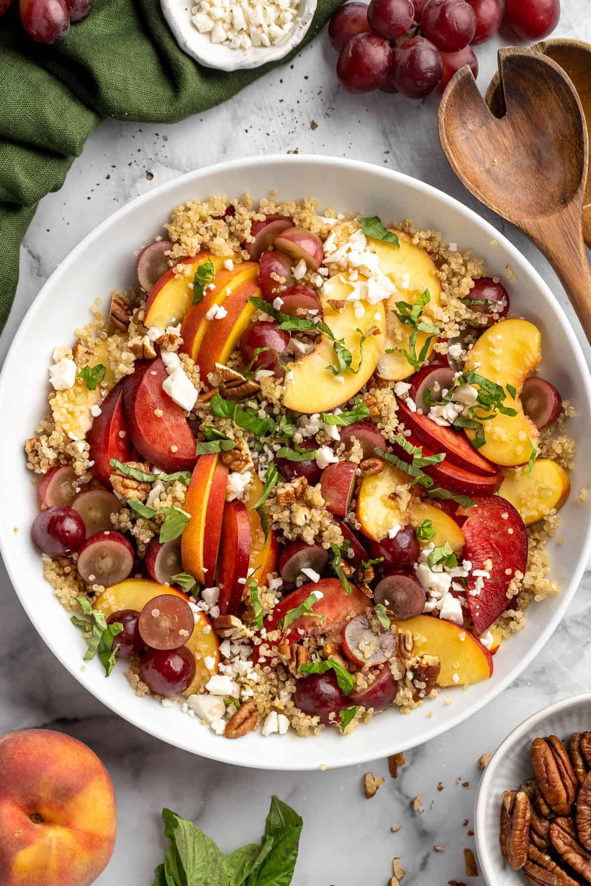Sweet, juicy summer fruit and fluffy quinoa come together in this beautiful quinoa stone fruit salad. It’s ready in just 20 minutes! Quinoa salad in bowl with peaches, plums, and grapes.