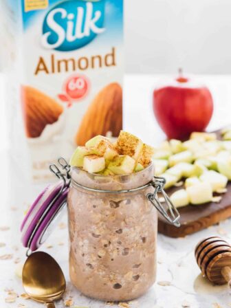 Apple cinnamon overnight oats in a glass jar, topped with diced apples.