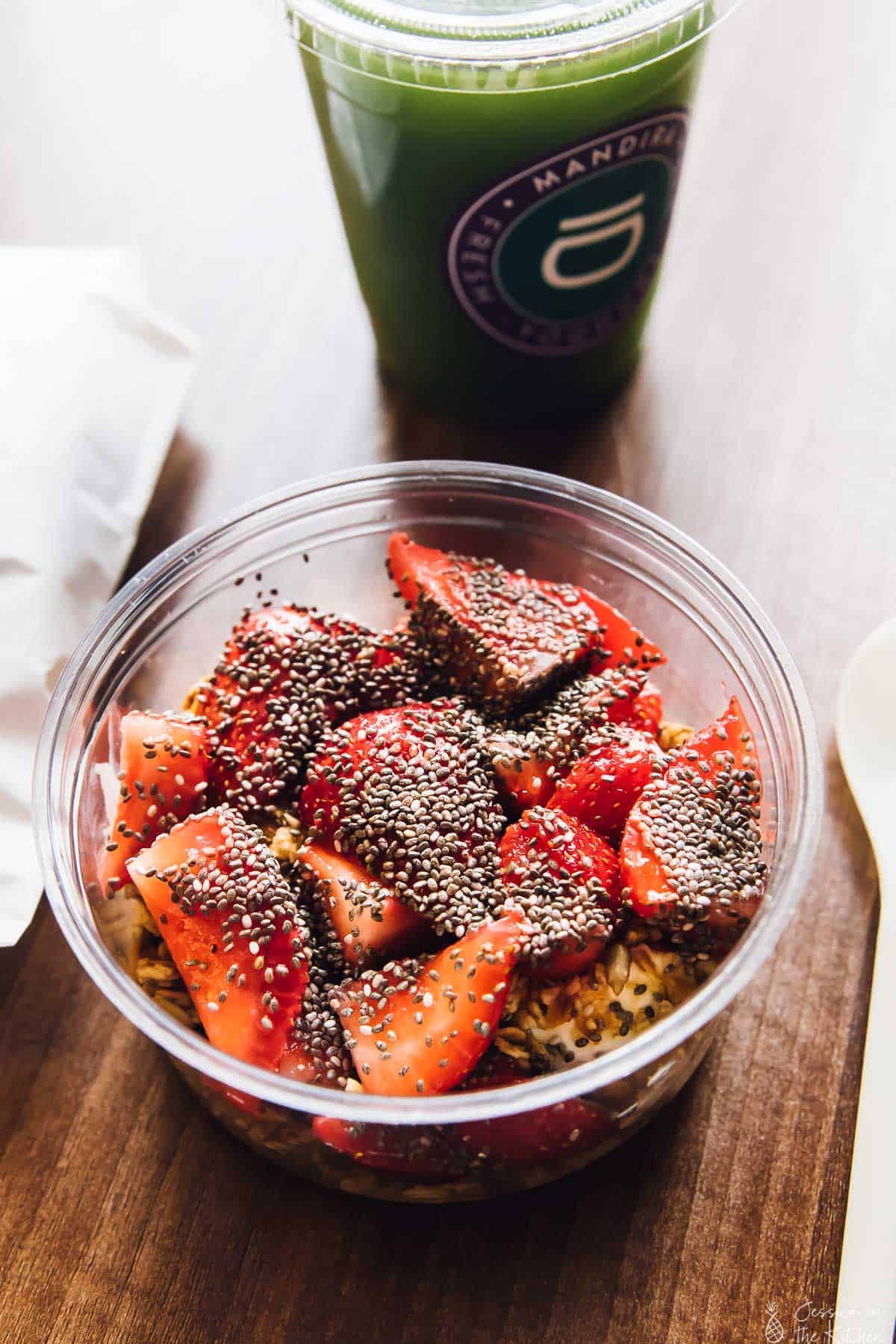 Top down view of strawberries and yogurt in a plastic container. 