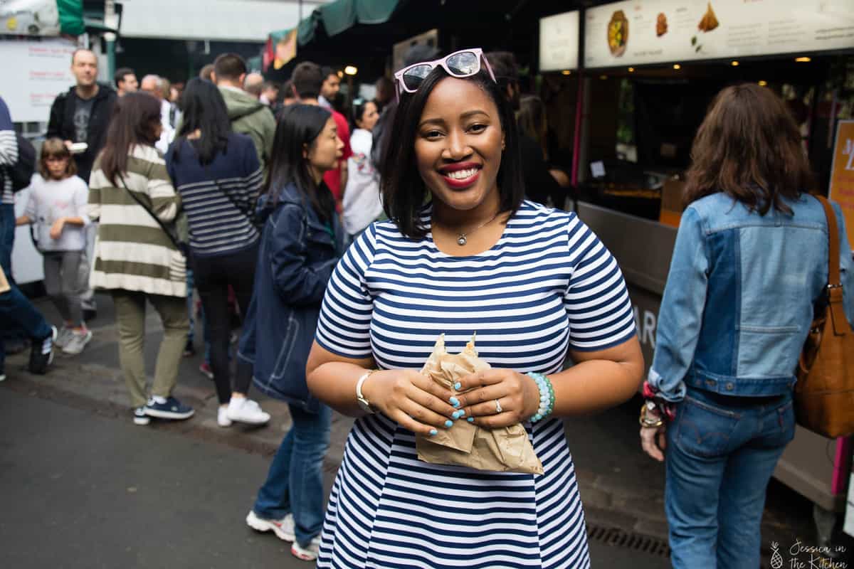 Jessica in a striped dress, standing in a market. 