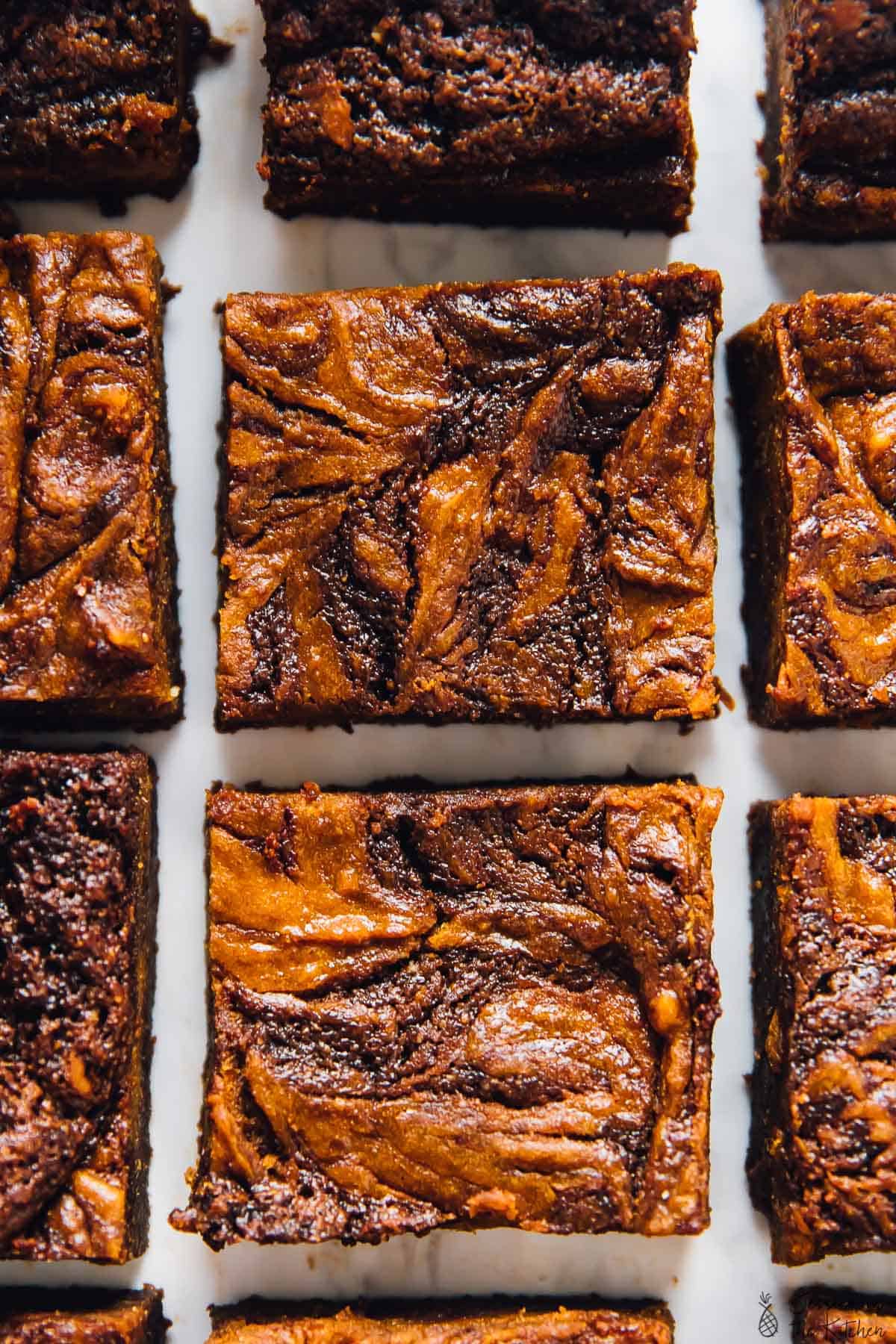 Overhead view of a few rows of brownies with cheesecake swirls