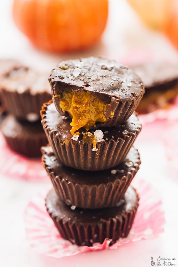 A stack of caramel chocolate cups on a pink cupcake liner. 