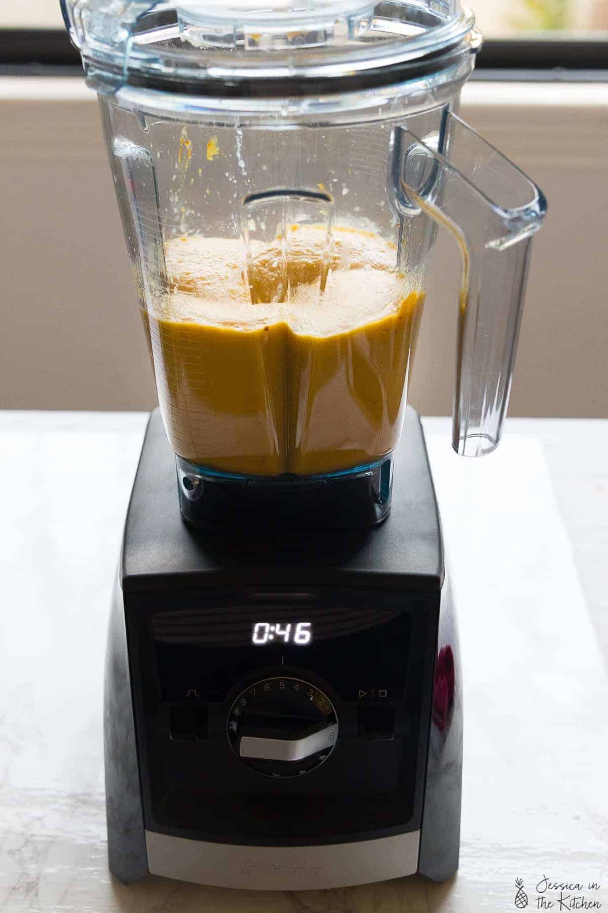 Side shot of butternut squash in a blender. 