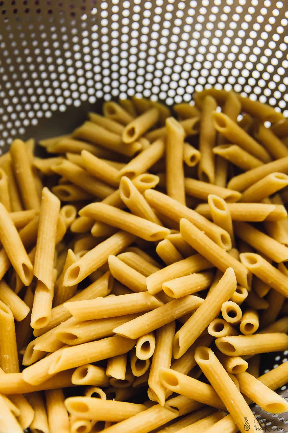 Overhead view of pasta in a colander. 