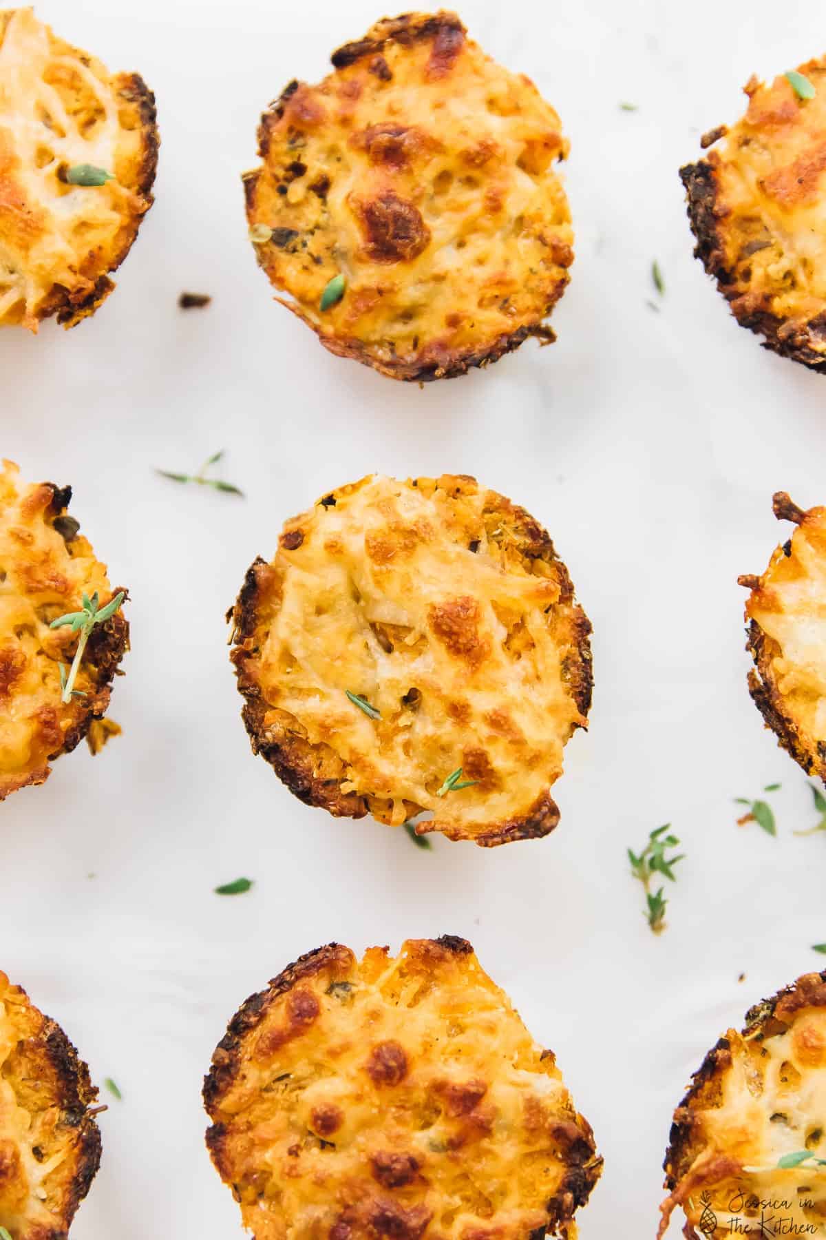 Top down view of cauliflower pizza bites on a white background.
