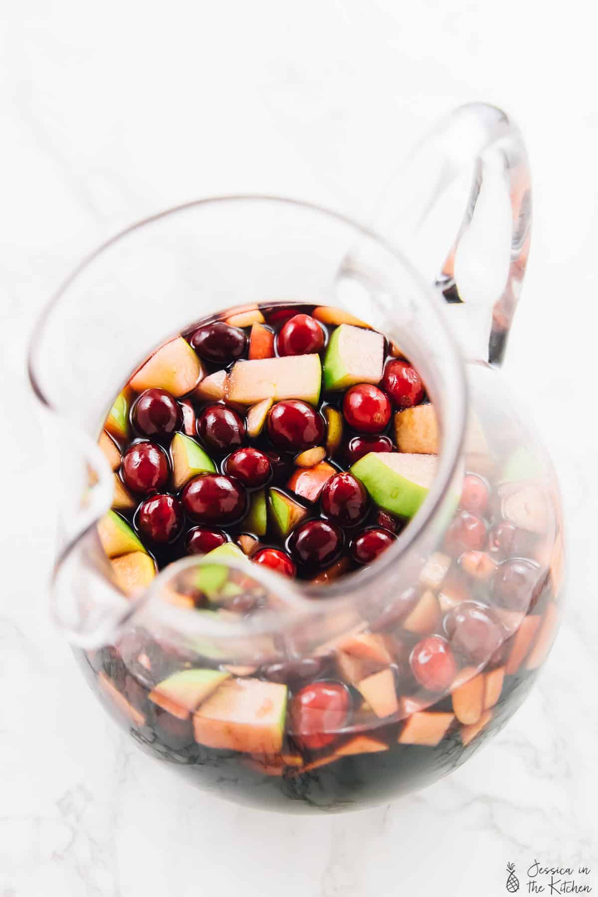Top down view of red wine apple cider fall sangria in a jug.