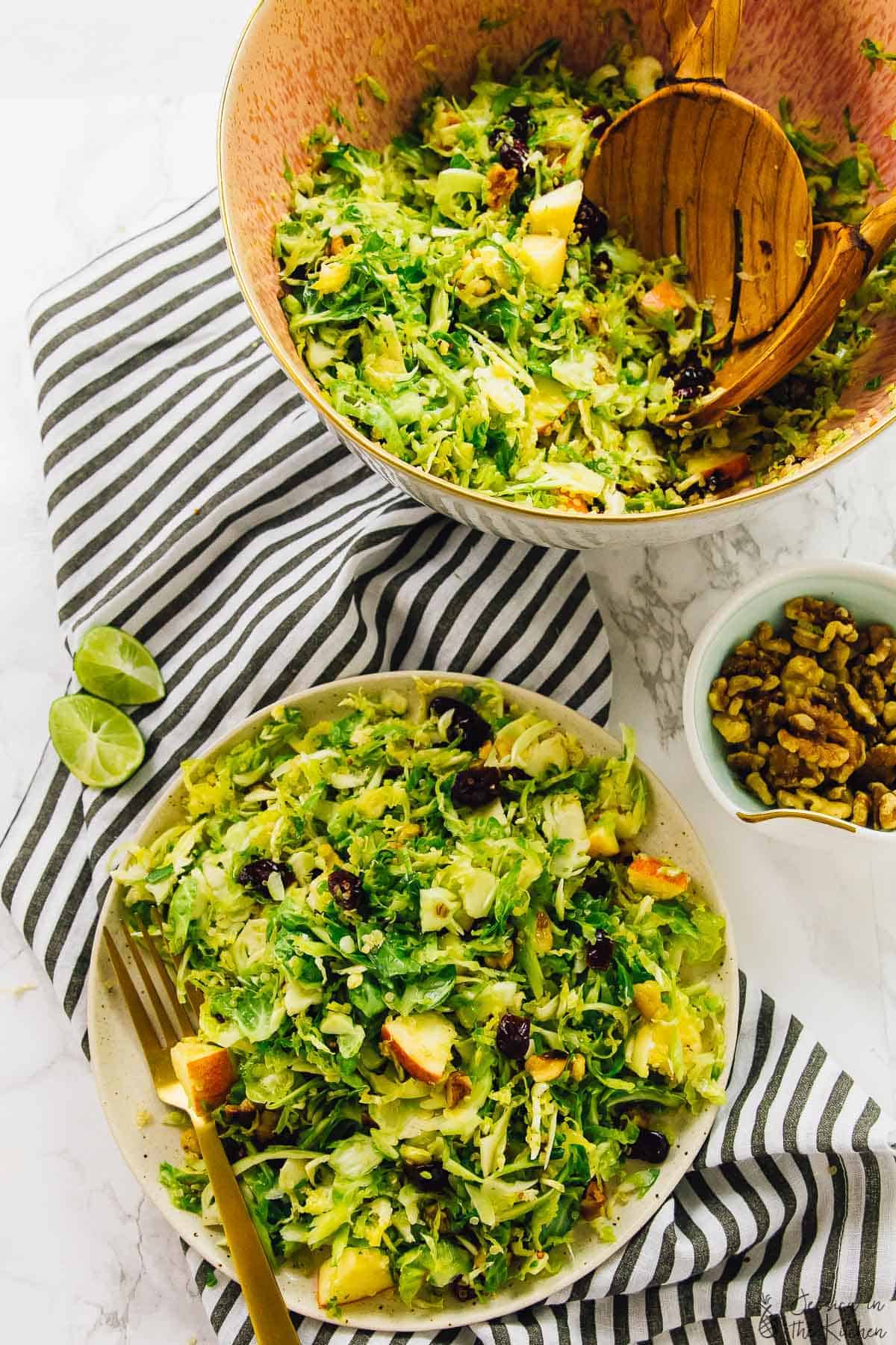 Overhead shot of shaved brussels sprouts, quinoa and apple salad in a bowl and on a plate. 