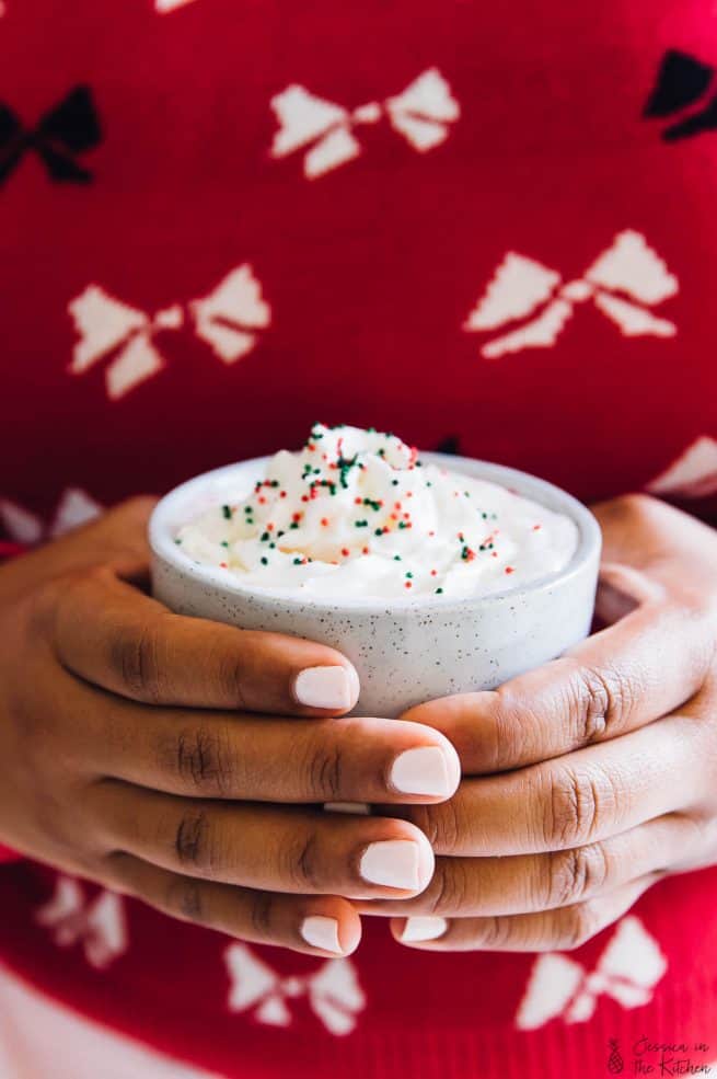 Hands holding a mug of hot chocolate.