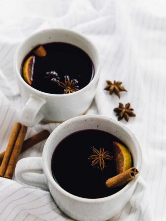 Two mugs of mulled wine on a striped cloth.