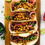 Overhead view of chickpea tacos on a wood board.