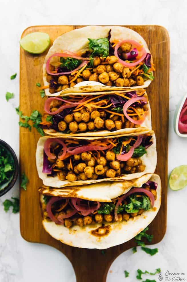 Overhead view of chickpea tacos on a wood board.