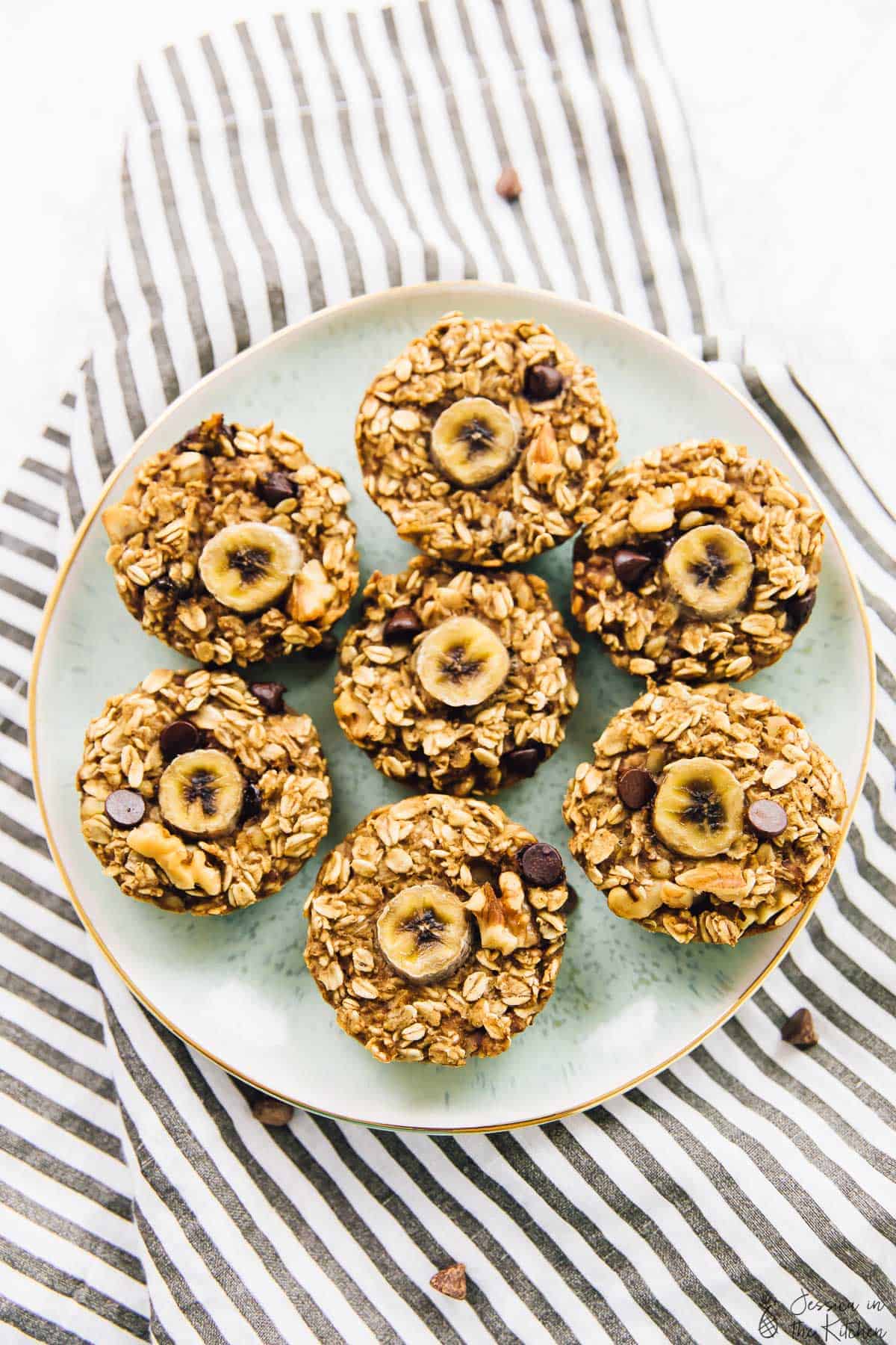 Top down view of baked banana bread oatmeal cups on a green plate. 