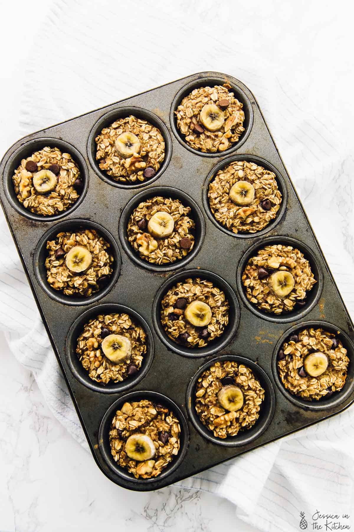 Overhead view of baked banana bread oatmeal cups in a muffin mold.