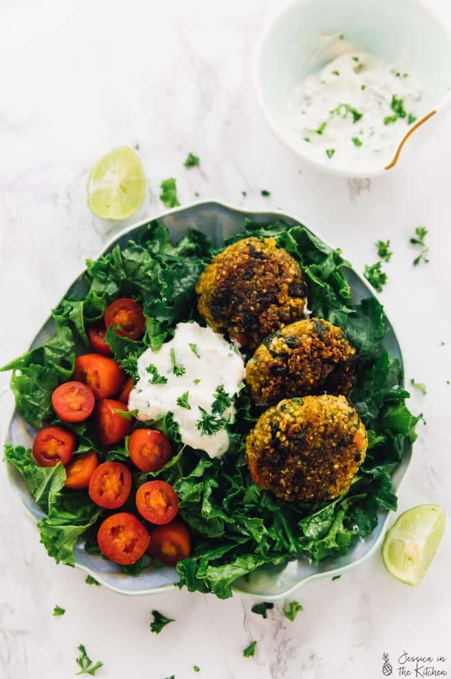 Top down shot of crispy quinoa patties on a bed of greens.