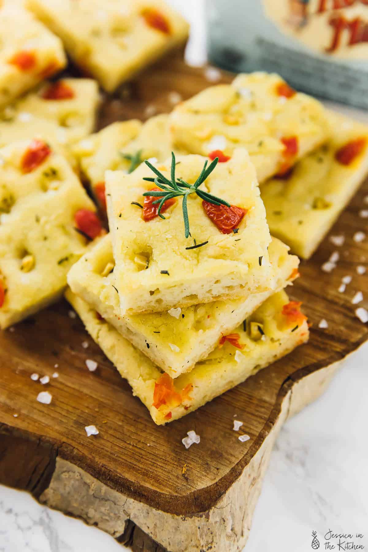 Squares of gluten free focaccia bread on a wooden board. 