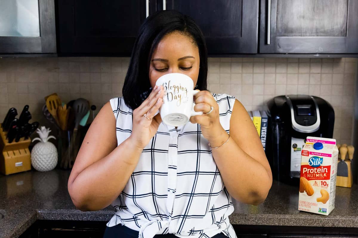 Jessica in her kitchen, taking a sip from a mug.
