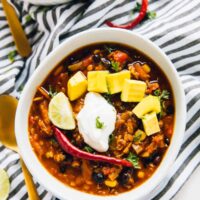 Overhead shot of red lentil chili in a white bowl.