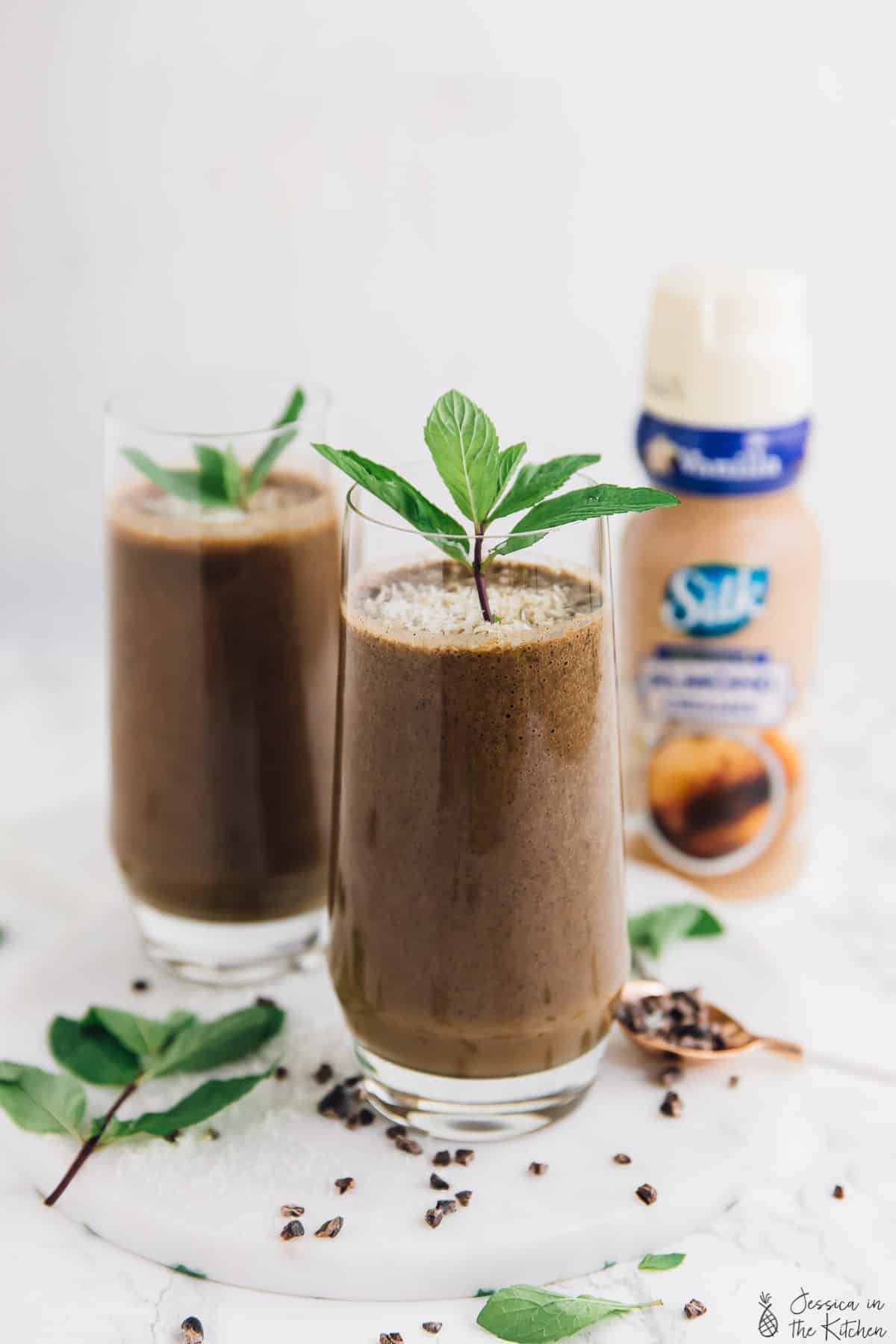 Two glasses of coffee shake, garnished with mint. 