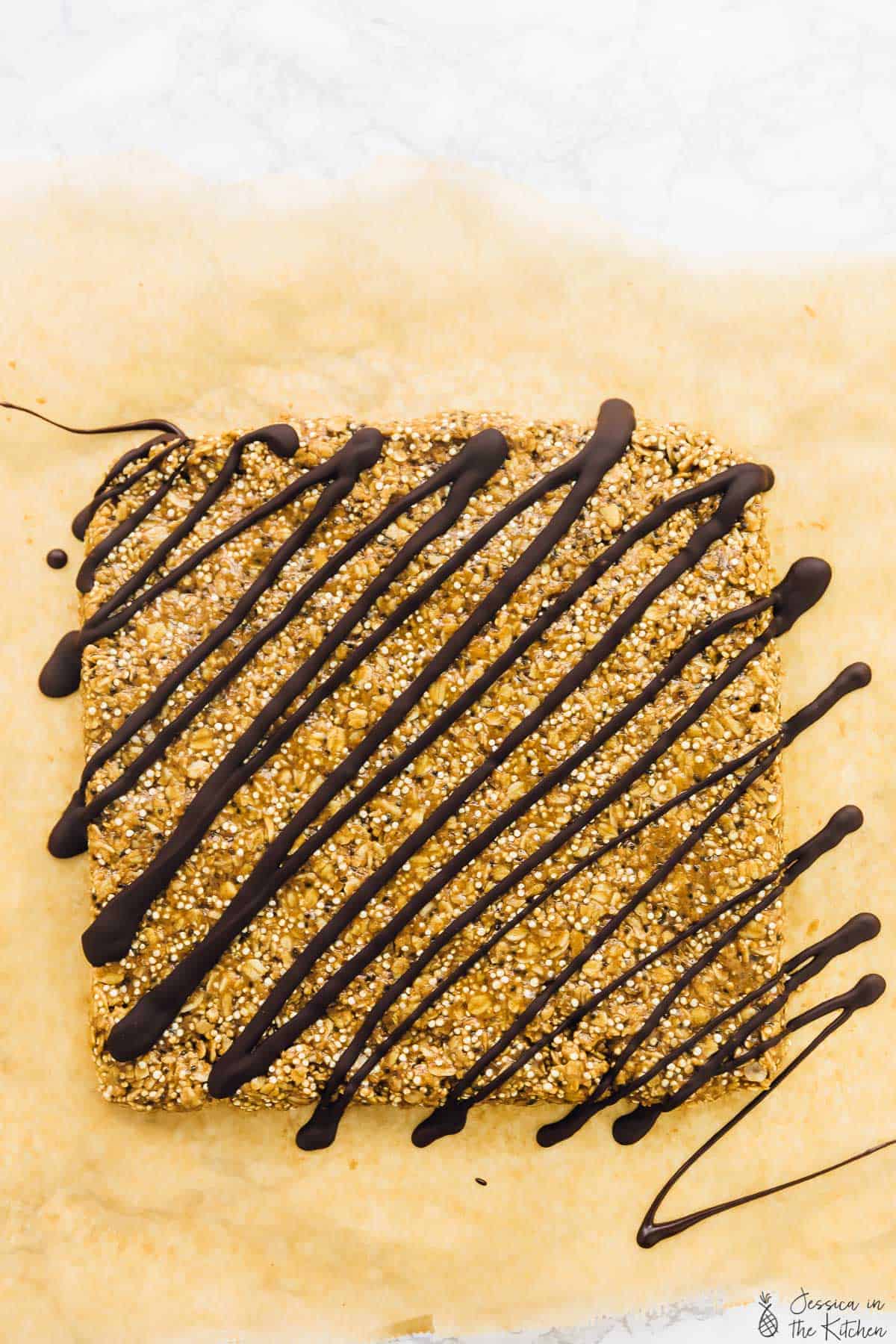 A slab of granola, drizzled in chocolate. 