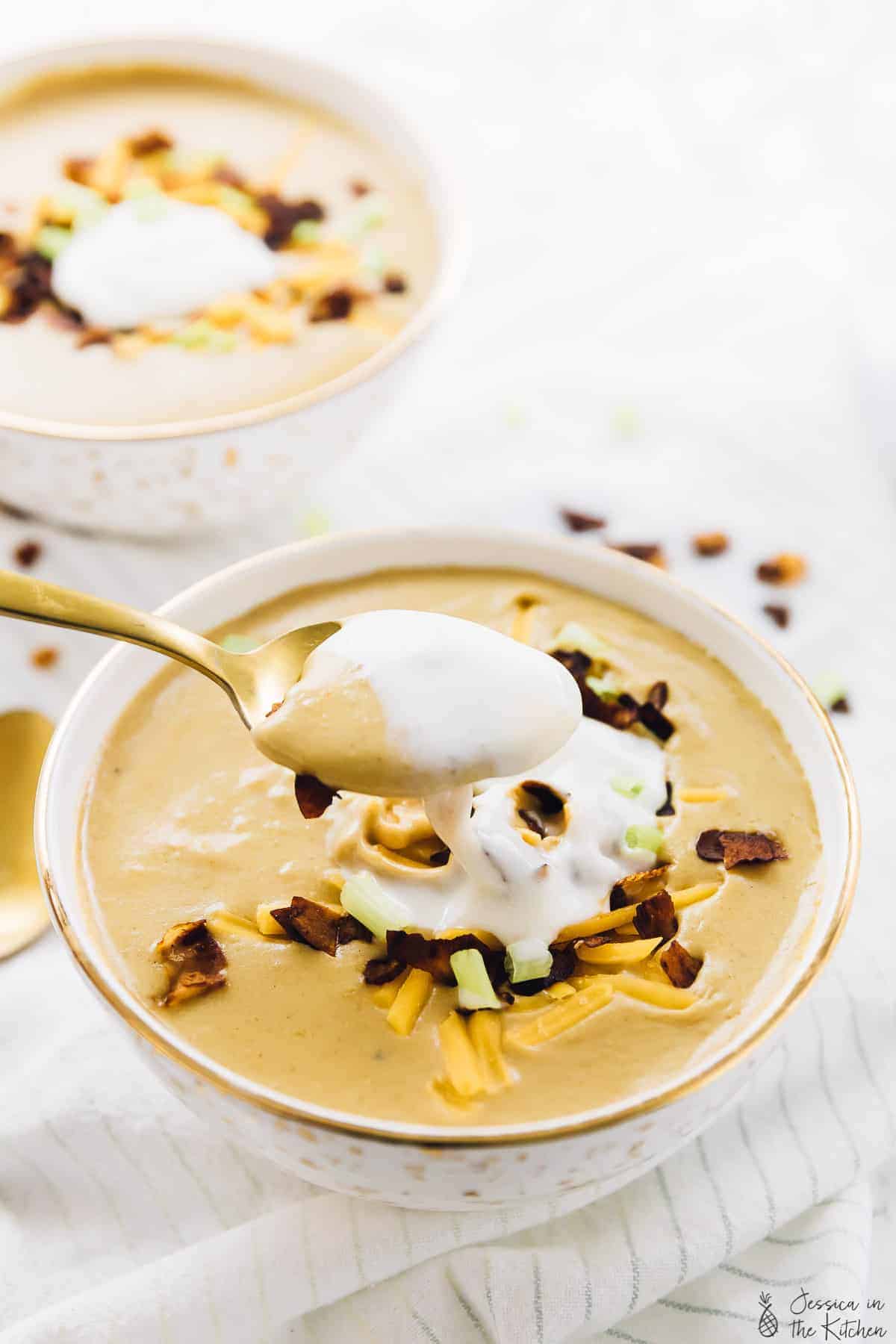 A bowl of vegan loaded potato soup, topped with coconut bacon. 